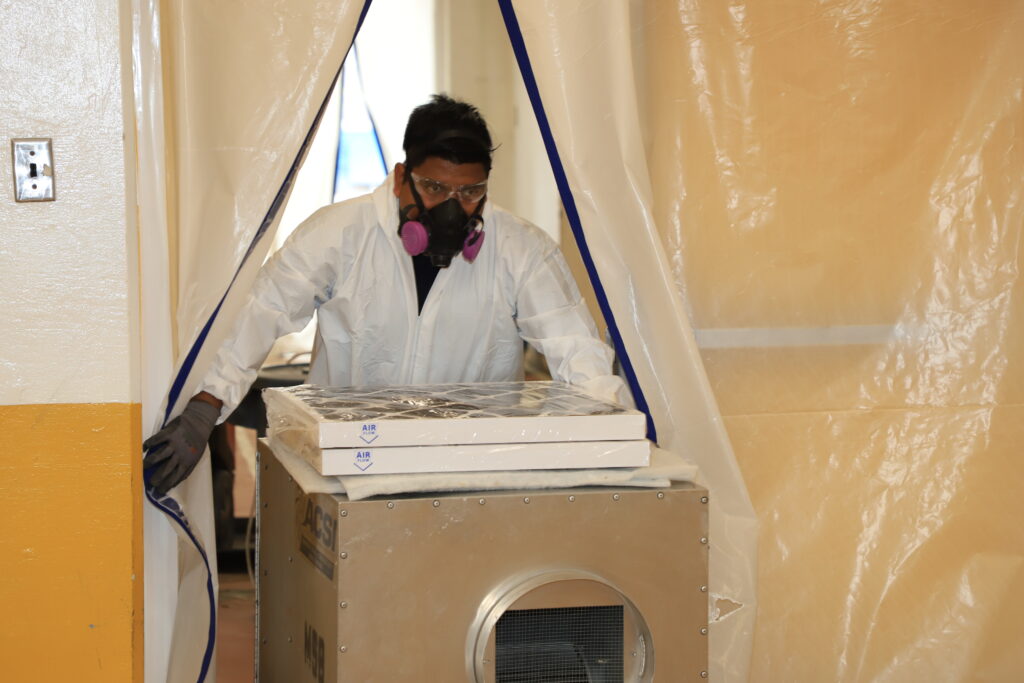 Staff with Dehumidifier at Basketball Court Large Water Damage Restoration