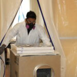 Staff with Dehumidifier at Basketball Court Large Water Damage Restoration