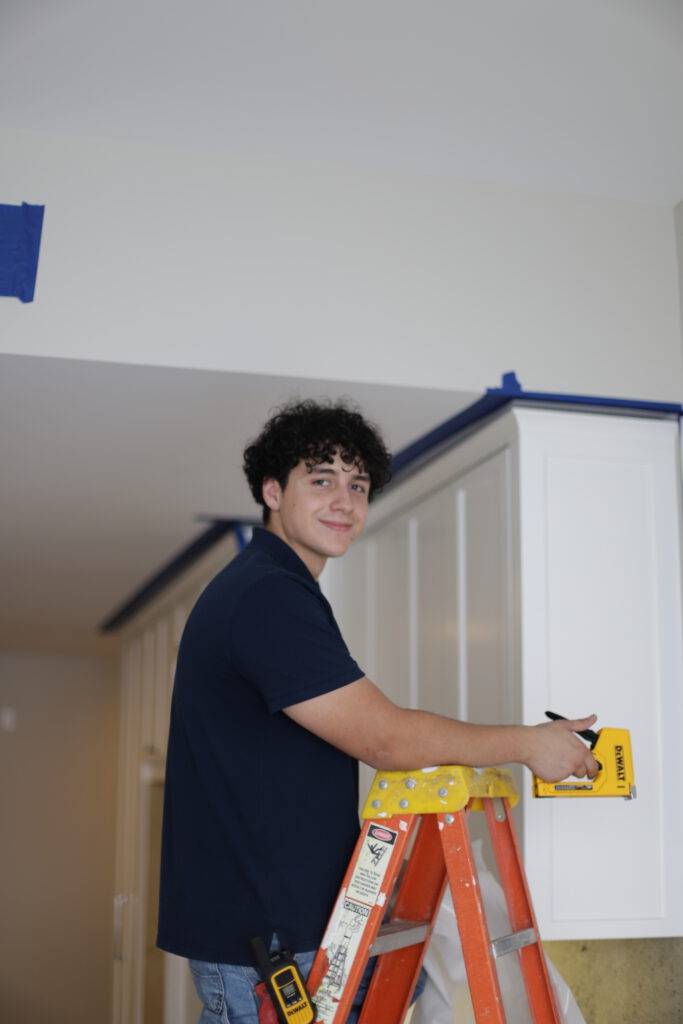 Restoration Technician Nick Taping off Cabinets